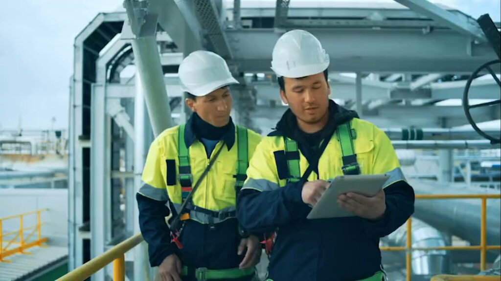 Ingenieure mit Helm prüfen Daten auf Tablet