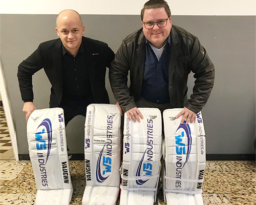 Zwei Männer stehen neben Eishockeytorwart-Schonern