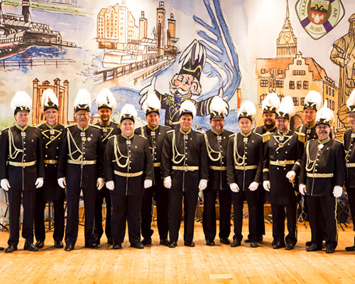 Gruppe von Feuerwehrleuten in Uniform vor Gemälde